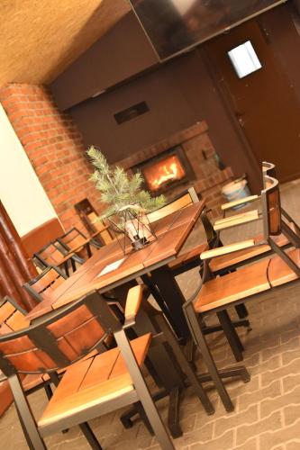 a dining room with a table and chairs and a fireplace at Hotel Dąbrowiak in Dąbrowa Górnicza