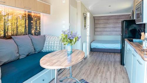 a living room with a couch and a table with flowers at Woodclose Park in Kirkby Lonsdale