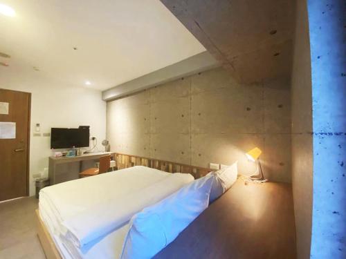 um quarto com uma grande cama branca e um candeeiro em M Taipei Hotel em Taipei