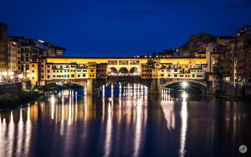 a bridge over a river in a city at night at Casa Moki in Uliveto Terme