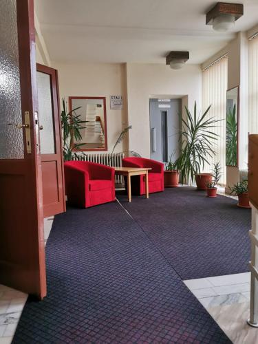 a lobby with two red couches and a table at HOTEL MUNTENIA in Campina