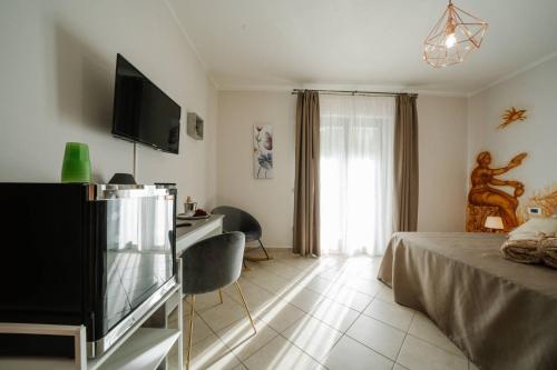 a bedroom with a bed and a television and a desk at Agriturismo Tenuta Don Carlo in Nocera Superiore