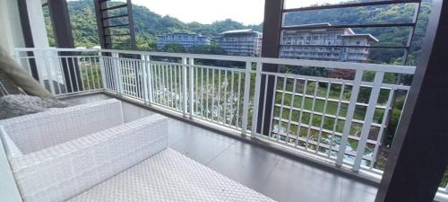 a balcony with a white railing and a white bench at Pico De Loro 2BR in Nasugbu