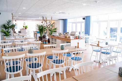 a restaurant with white tables and chairs at Hotel Marie in Skagen