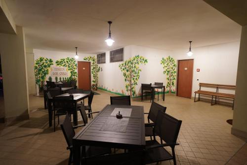 a restaurant with tables and chairs and a wall with ivy at Agriturismo Tenuta Don Carlo in Nocera Superiore
