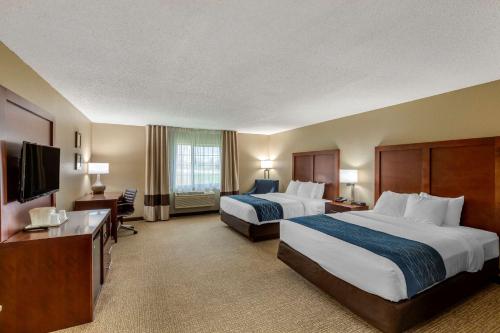 a hotel room with two beds and a flat screen tv at Comfort Inn & Suites Jackson - West Bend in Jackson