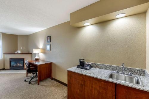 a room with a kitchen with a sink and a desk at Comfort Inn & Suites Jackson - West Bend in Jackson