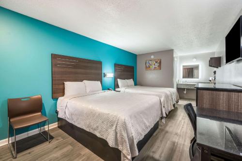 1 dormitorio con 2 camas y pared azul en Econo Lodge, en Russellville