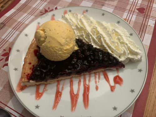 a white plate with a pie with a scoop of ice cream at La Chanterelle - Mountain Lodge in La Côte dʼArbroz