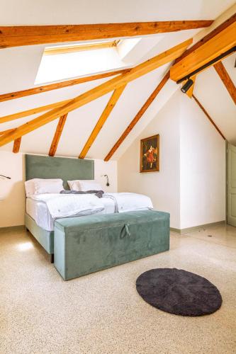 a attic bedroom with two beds and a rug at Vila Brinovka in Kostanjevica na Krasu