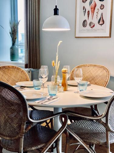 a dining room table with chairs and a pendant light at Hotel Marie in Skagen