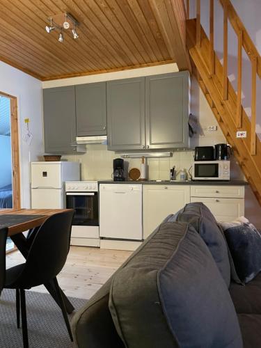 een woonkamer met een bank en een keuken bij Rukan Tähtihelmi Kelokivakka b12 in Ruka