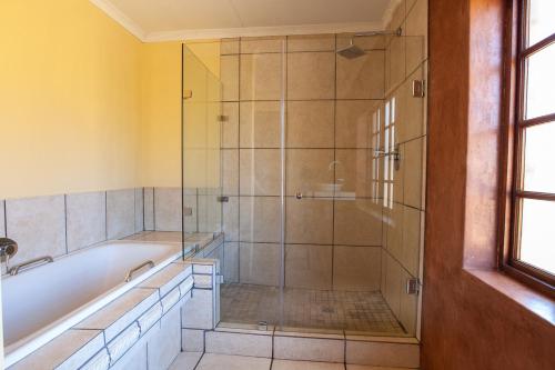 ein Badezimmer mit Dusche und Badewanne in der Unterkunft Crimson Cottage in Dullstroom