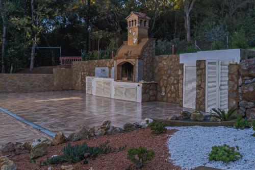 a outdoor kitchen with a clock tower in a yard at Villa Liam con Piscina - Goelba in Portoferraio
