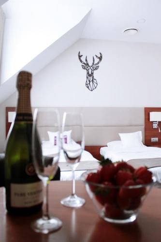 two glasses of wine and a bowl of fruit on a table at ParkHotel Łysoń in Inwałd