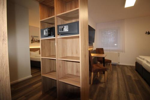 Cette chambre comprend une étagère avec une table et un lit. dans l'établissement Hotel Stubbe, à Papenbourg