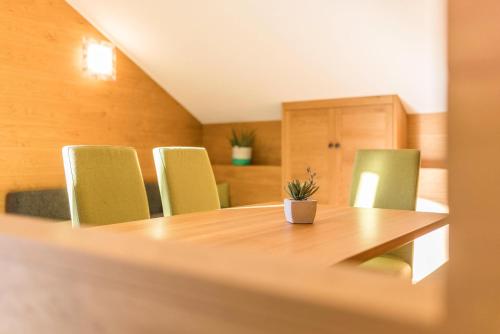 a conference room with a wooden table and green chairs at Rosalpina Apt 3 in San Vigilio Di Marebbe