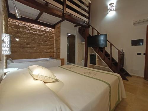 a bedroom with a bed with a tv on the wall at Agriturismo Porticciolo in Porto Conte