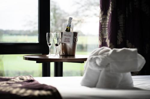 a table with a bottle of wine and a glass at Ballyrobin Hotel in Aldergrove