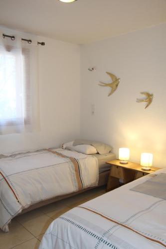 - une chambre avec deux lits et deux lumières sur le mur dans l'établissement L'orée des pistes Serre Chevalier Briançon, à Briançon