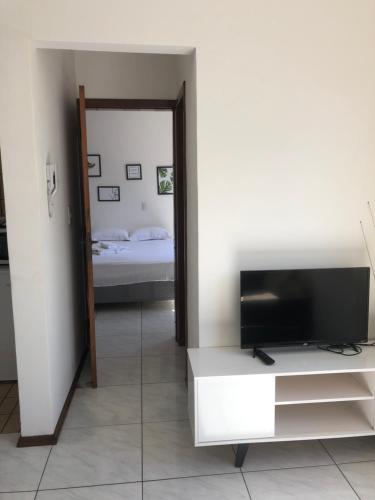 a living room with a television and a bedroom at Abdon Batista - Apto completo central, Smart TV in Joinville
