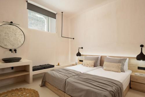 a white bedroom with a large bed and a mirror at Isla Beach House, a Timeless Retreat, By ThinkVilla in Damnoni