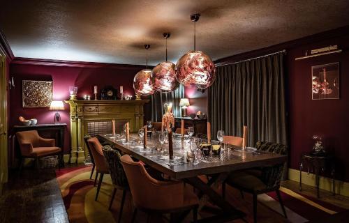 un comedor con una mesa larga y sillas en The Glenmorangie House, en Tain