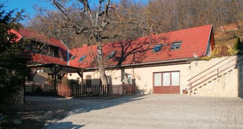 uma casa com um telhado vermelho e uma entrada em Bóbita Háza em Eplény