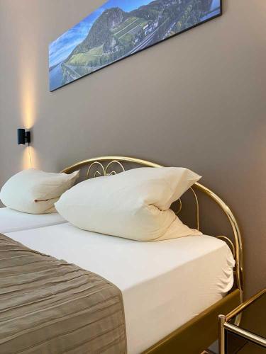 1 cama con almohadas blancas y una foto en la pared en Weingut Pieper - Vinothek & Hotel am Drachenfels en Bad Honnef am Rhein