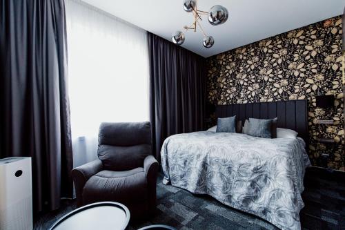 a bedroom with a large bed and a large window at Hotel Color in Bratislava