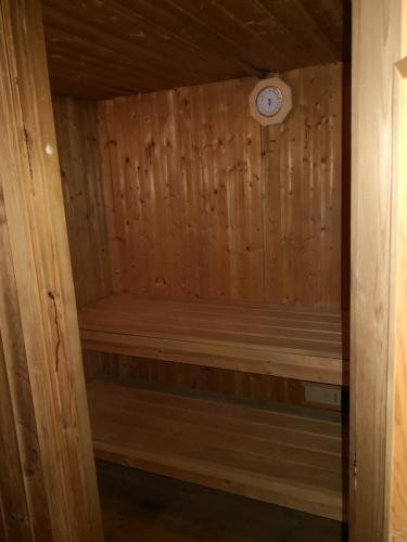 a wooden sauna with a clock on the wall at Roubenka nad řekou in Noviny pod Ralskem
