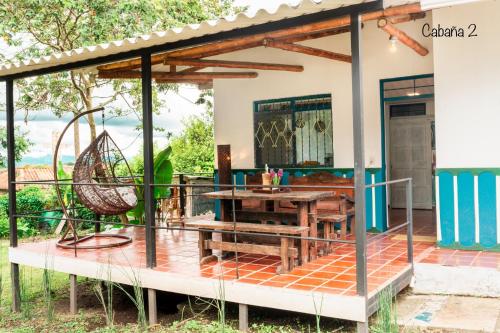 a house with a deck with a table and a swing at Hotel campestre La Esperanza en Dios in Montenegro