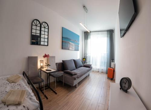 Apartament Loftowy Wypoczynek GoldAir في بوزنان: غرفة معيشة مع أريكة وطاولة