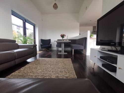 a living room with a couch and a flat screen tv at Tiger House Luxury Riverside Home in Stockton-on-Tees