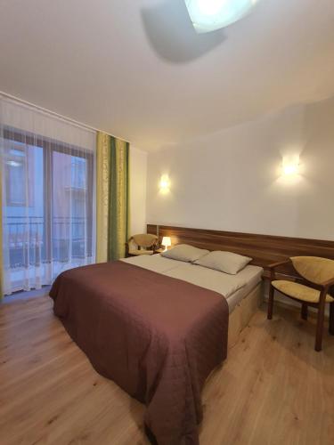 a bedroom with a bed and a large window at Villa Amber in Międzywodzie