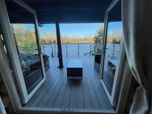 a porch with a view of the water from a boat at Woodpecker Log Cabin with hot tub, pizza oven bbq entertainment area, lakeside with private fishing peg situated at Tattershall Lakes in Tattershall