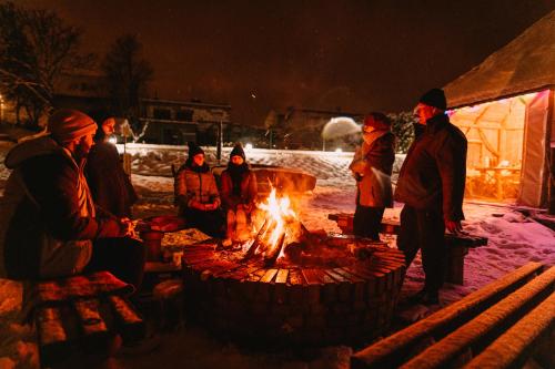 a group of people standing around a fire pit at KASZUBY SeliRaj GospAgro Alpaki,dwa pokoje-niezależnie wejście in Dzierzążno