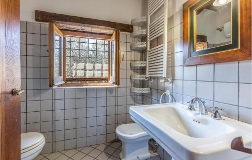 bagno con lavandino, servizi igienici e finestra di Beautiful Home In Alvignano With Kitchen ad Alvignano
