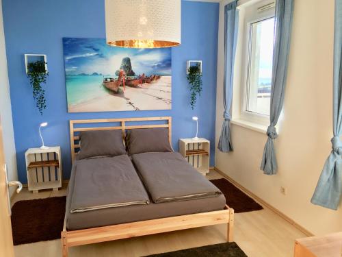Oberschützen的住宿－Apartment Panoramablick mit Infrarotkabine auf der großen Terrasse und traumhaften Ausblick，一间卧室设有一张床和蓝色的墙壁