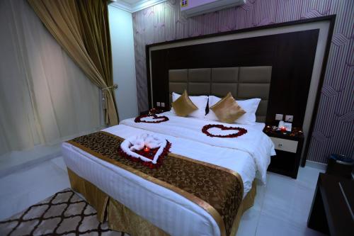 a bedroom with a large bed with white sheets and pillows at جراند سيزون للشقق المخدومة in Dammam