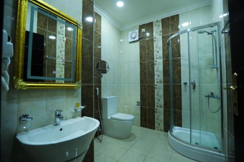 a bathroom with a sink and a toilet and a shower at جراند سيزون للشقق المخدومة in Dammam