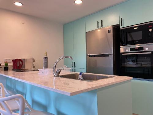 a kitchen with a sink and a refrigerator at Top Royal Eilat רויאל פארק in Eilat