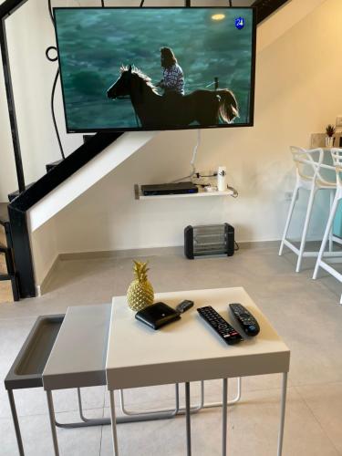 a living room with a tv and a coffee table at Top Royal Eilat רויאל פארק in Eilat