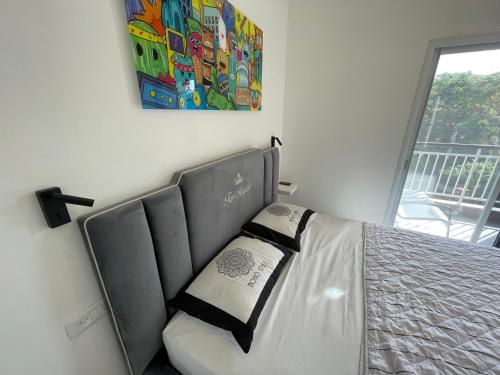 a bed in a bedroom with a painting on the wall at Top Royal Eilat רויאל פארק in Eilat