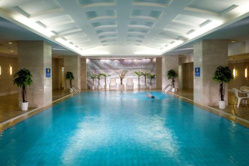 a swimming pool in a hotel with a person laying in it at Grand Mercure Beijing Central in Beijing