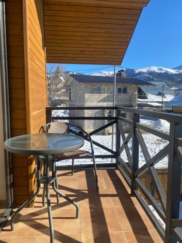een balkon met een tafel en uitzicht op de sneeuw bij Bakuriani Cozy Villa #4 in Bakuriani