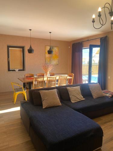 een woonkamer met een blauwe bank en een tafel bij Bakuriani Cozy Villa #4 in Bakuriani