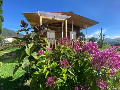 una casa con flores púrpuras delante de ella en Serás Libre Refugio, en Zipaquirá