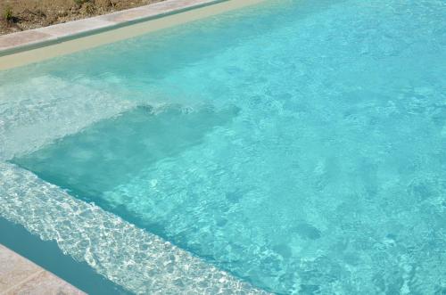 a swimming pool with blue water in it at Chez Madeleine in Saint-Colomb-de-Lauzun