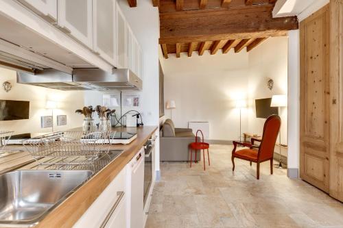 une cuisine avec des placards blancs et une table avec une chaise dans l'établissement La Maison Debourg, à Lyon